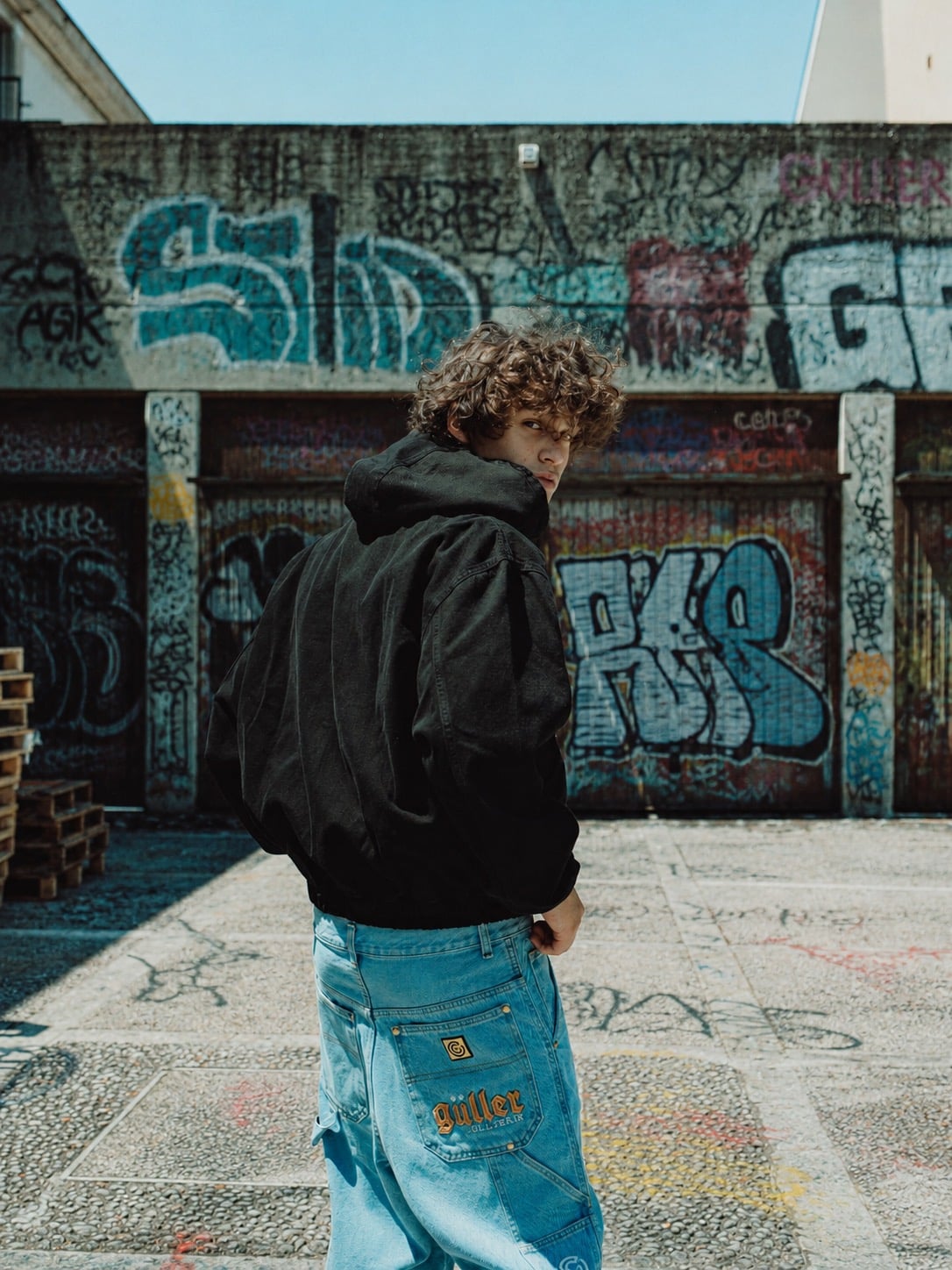 Giacca Güller di spalle davanti a un muro di graffiti